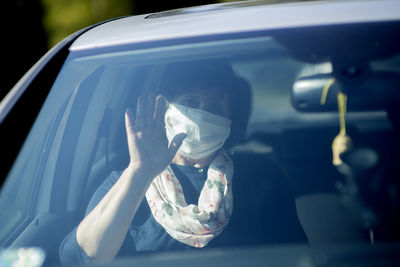 Portrait of man holding car window