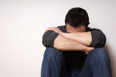 Man and woman against wall against white background