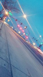 Illuminated road against sky at night