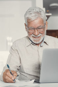 Portrait of senior man working at home