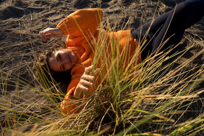 Rear view of woman lying down on land