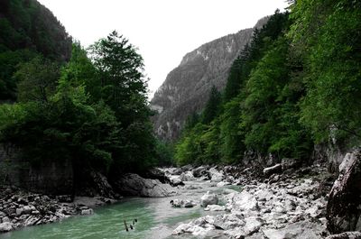 Scenic view of waterfall and mountains against sky