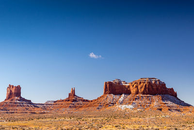 Rock formations in desert against blue sky