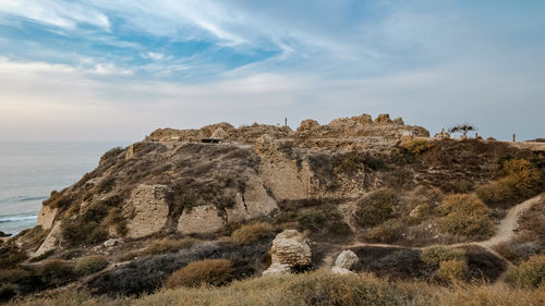 Rock formations by sea against sky