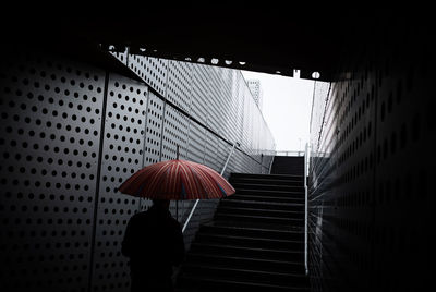 Woman standing on wet umbrella during rainy season