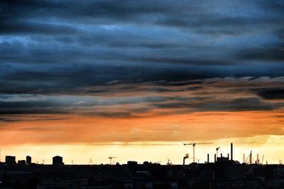 Silhouette city against sky during sunset