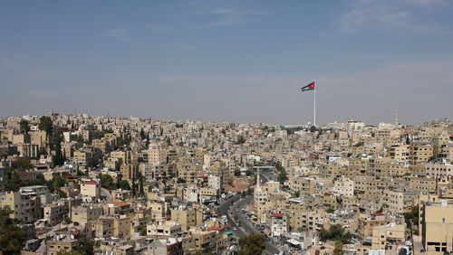 Panorama of amman city with big jordan flag 