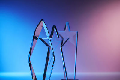 Group of star shape crystal trophies against blue and pink background