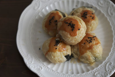 There are some delicious black sesame egg yolk pastries freshly baked on the plate on the table