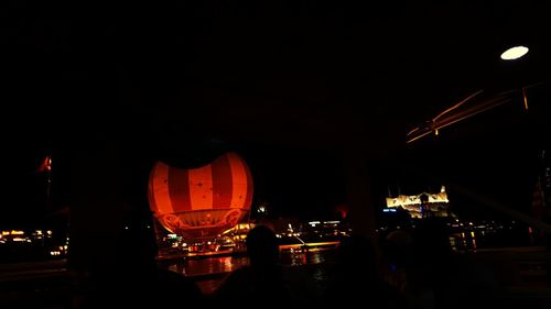 Illuminated ferris wheel against sky at night