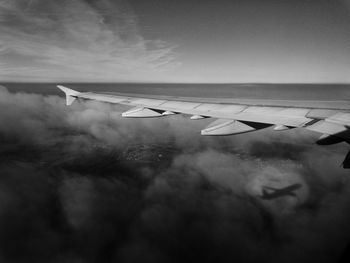 Airplane flying over water against sky