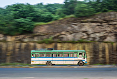Bus moving on road against mountain