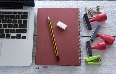 High angle view of diary and office supply with laptop on table