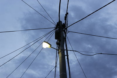 Low angle view of electricity pylon against sky