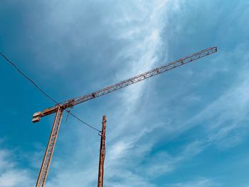 Low angle view of crane against sky