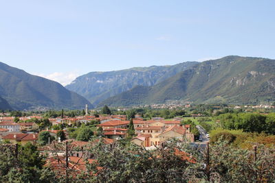 Scenic view of townscape by mountains against sky