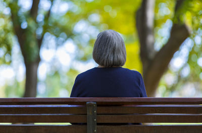 Rear view of woman sitting on bench