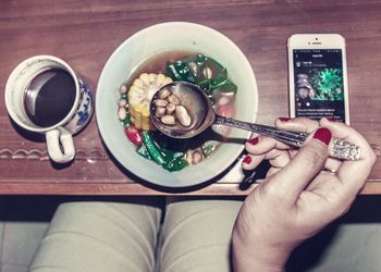 Cropped image of woman eating breakfast at home