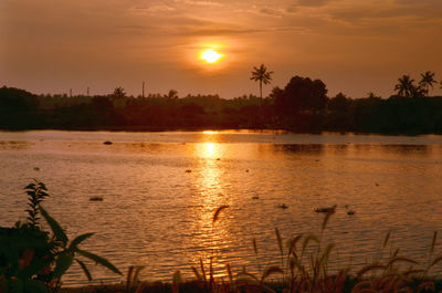 Scenic view of lake against orange sky