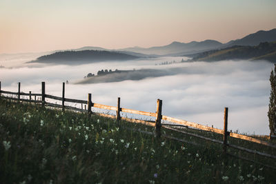 View of wooden railing against cloudscape