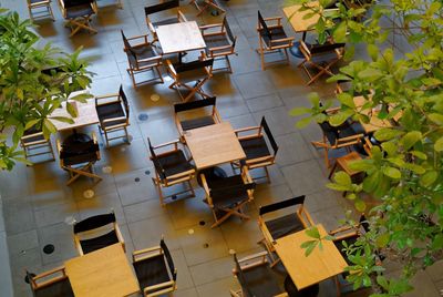 Empty chairs and table arranged in sidewalk cafe