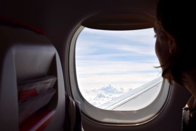 Portrait of woman looking through airplane window 