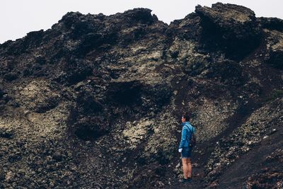 Rear view of person standing on rock