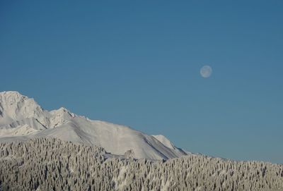 Scenic view of snowcapped mountains against clear blue sky