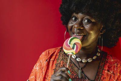 African woman happily enjoying her lollipop wearing african style