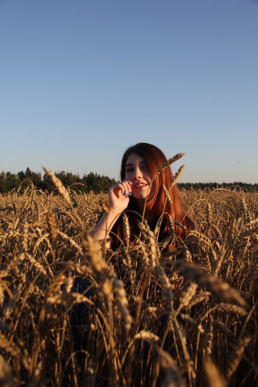 field, one person, land, sky, plant, young adult, rural scene, landscape, lifestyles, nature, front view, real people, agriculture, leisure activity, crop, cereal plant, young women, clear sky, farm, outdoors