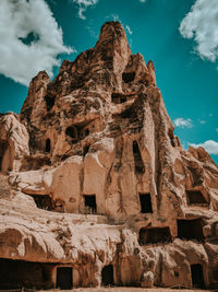 Low angle view of rock formation against cloudy sky