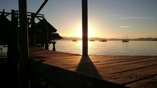 Silhouette pier on sea against sky at sunset