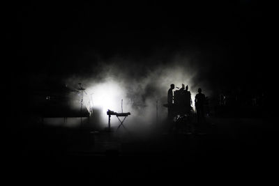 Silhouette man and illuminated stage at concert