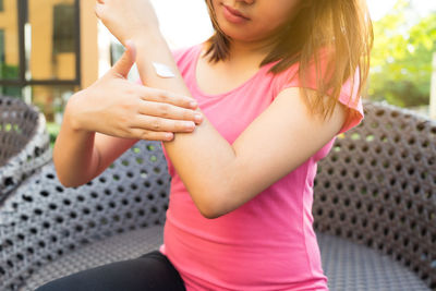 Midsection of woman holding pink flowers