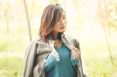 Young woman looking away in forest