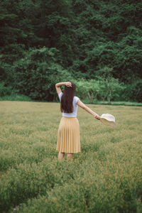 Rear view of woman standing on field