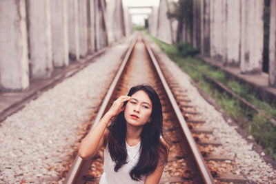 Portrait of young woman on railroad track