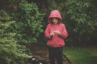 Portrait of boy standing against plants