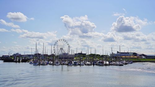 Sailboats in amusement park against sky