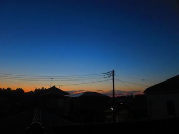 Silhouette houses against sky during sunset