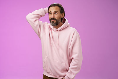 Man standing against pink background