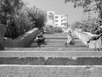People on staircase against trees