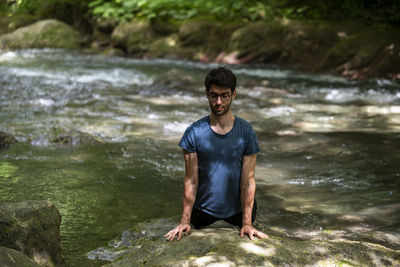 Portrait of young man jumping in lake