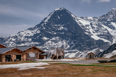 Houses on snowcapped mountain against sky