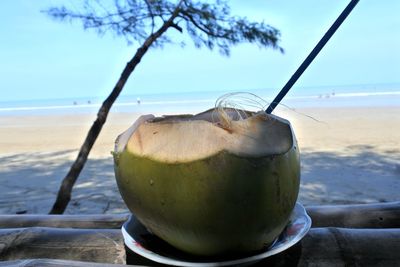 Close-up of drink on beach against sky