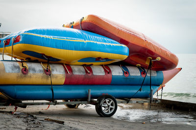 Water inflatable boats stacked at the beach.