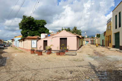 Street amidst houses and buildings against sky