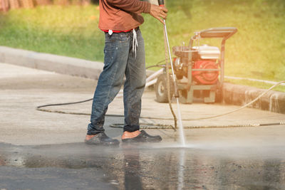 Low section of man standing on wet shore