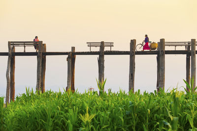 People working on railing against clear sky