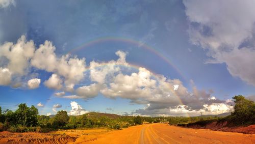 Scenic view of rainbow over road against sky